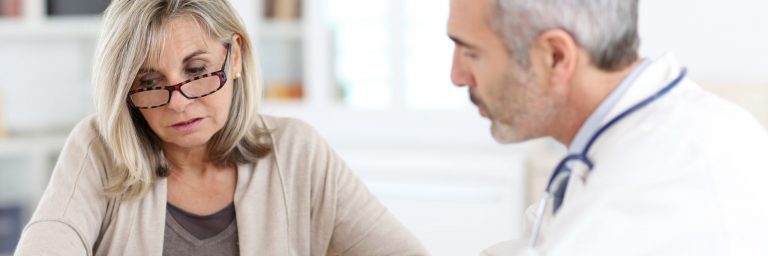 Doctor giving medicine to senior woman for arthritis pain