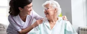 Pflegehilfskraft mit Bewohnerin im Pflegeheim