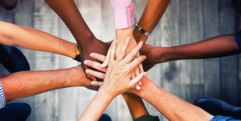 Mehrere Hände fassen kreisförmig aufeinander.