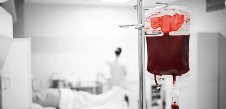 Blutkonserve an Infusionsständer in Krankenhausumgebung.