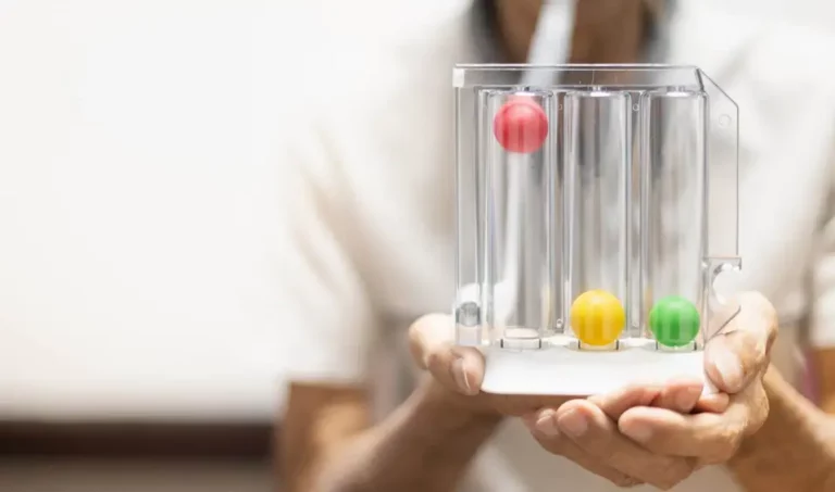 Person nutzt Atemtrainer mit drei bunten Kugeln.