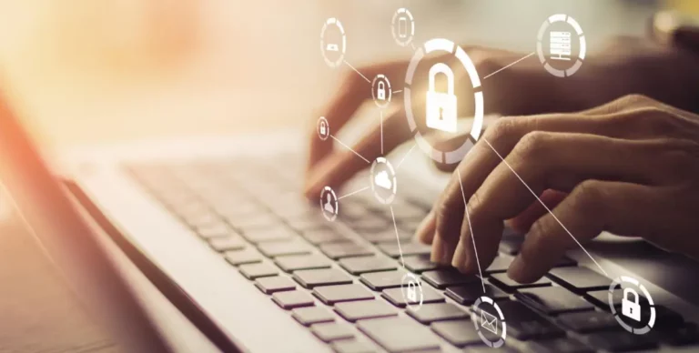 Hände tippen auf Laptop-Tastatur mit eingeblendeten Sicherheitssymbolen.