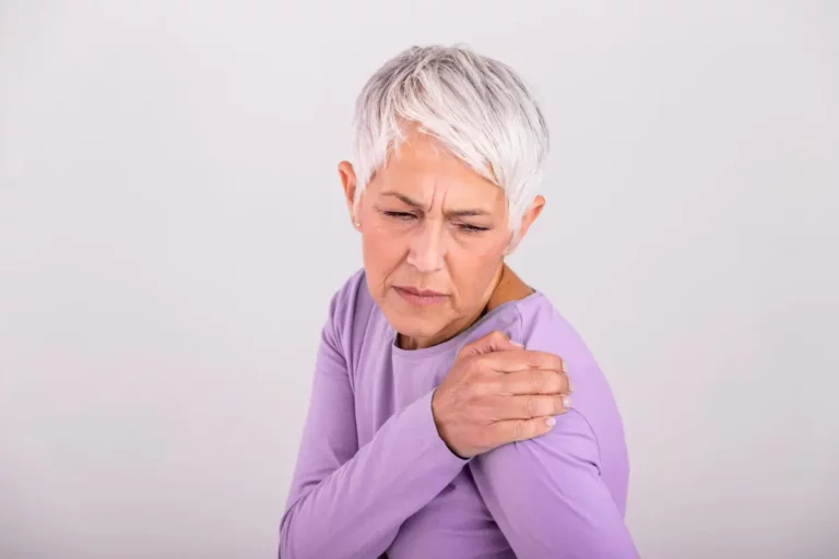 Ältere Frau greift schmerzhaft an ihre Schulter