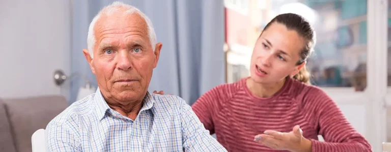 Älterer Mann schaut ernst, Frau spricht emotional mit ihm.