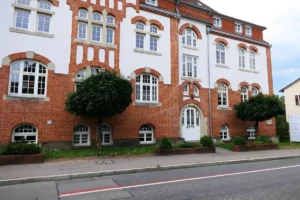 Paulinenpflege Winnenden: Historisches Gebäude mit roter Backsteinfassade und weißen Fenstern in gepflegter Umgebung.