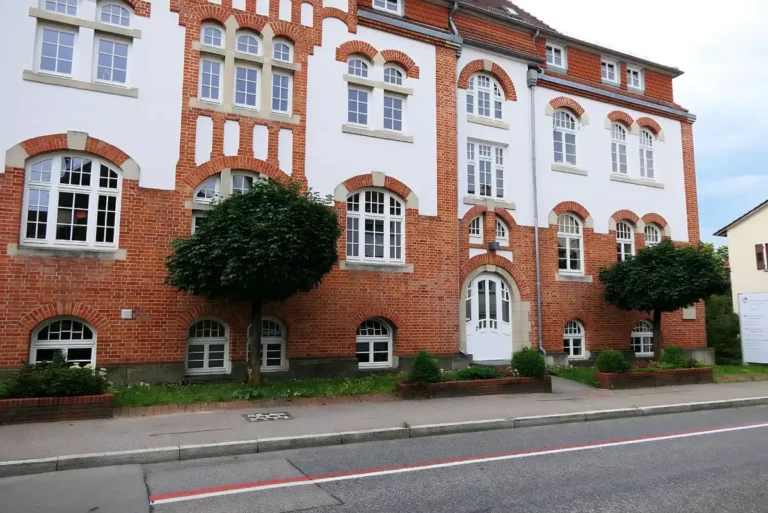 Paulinenpflege Winnenden: Historisches Gebäude mit roter Backsteinfassade und weißen Fenstern in gepflegter Umgebung.