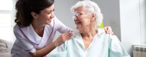 Pflegehilfskraft mit Bewohnerin im Pflegeheim