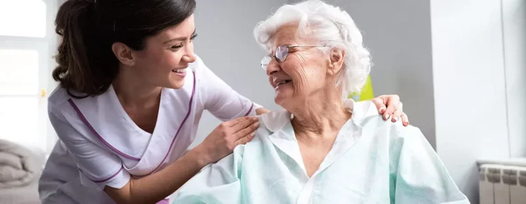 Pflegehilfskraft mit Bewohnerin im Pflegeheim