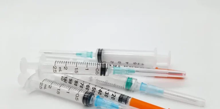 Mehrere Spritzen mit aufgesetzten Nadeln auf weißem Untergrund.