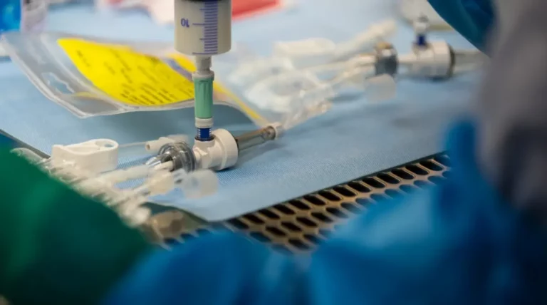 Nahaufnahme eines sterilen Zugangs mit angeschlossener Spritze im Klinikbereich.