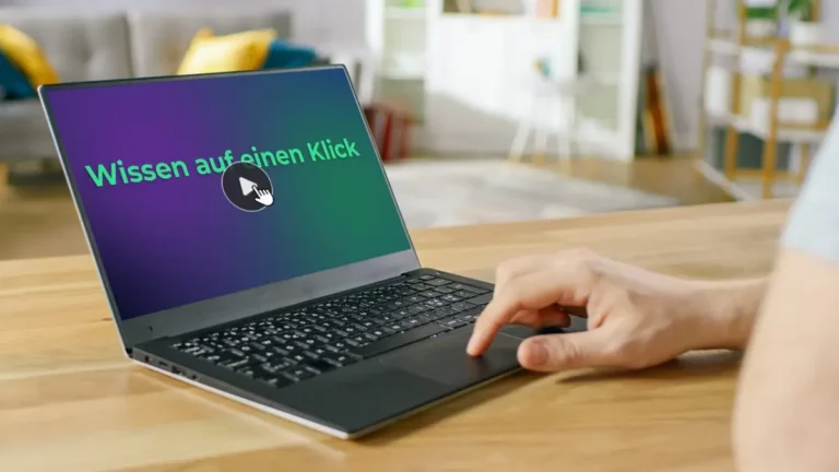 Hand bedient Laptop mit Schriftzug „Wissen auf einen Klick“.
