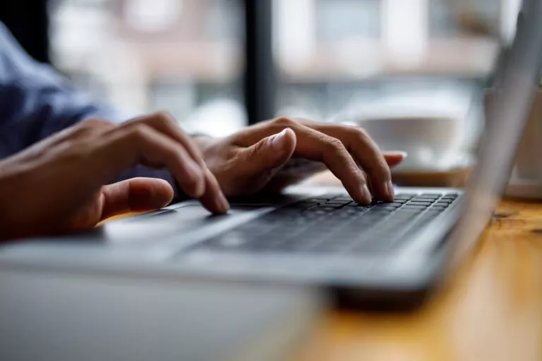 Close up of hands typing on computer keyboard panoramic banner,