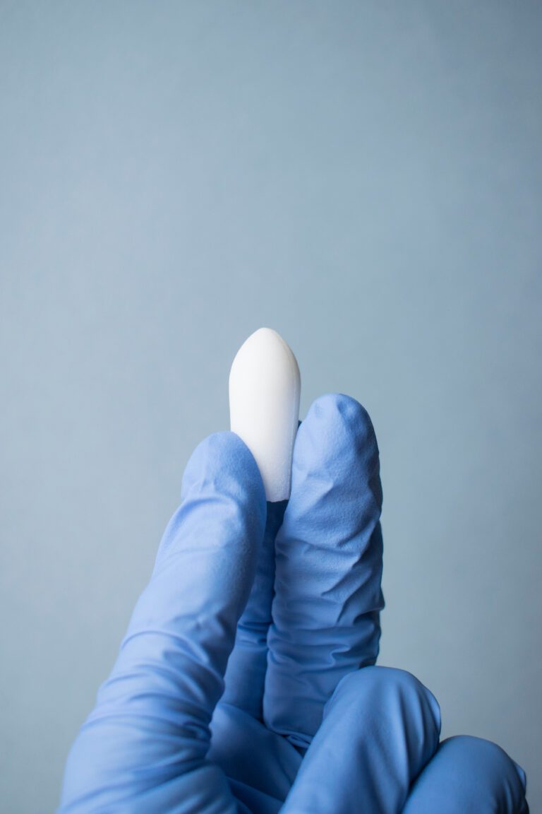 A doctor’s hand in a glove holds a vaginal rectal anal suppository. Candle from hemorrhoids, pain, fever, thrush, vaginitis, inflammation, constipation, infections