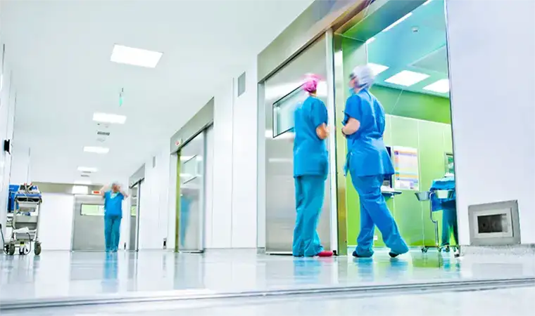 Krankenhausflur mit 2 Pflegepersonen in PSA
