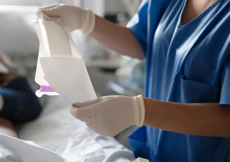 Hände einer Pflegeperson beim Anlegen von Handschuhen vor Wundbehandlung.