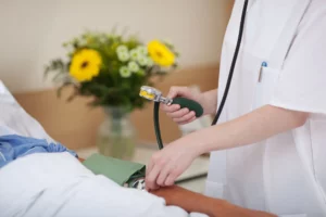 Ärztin misst einer Patientin den Blutdruck – Delegation von Behandlungspflege