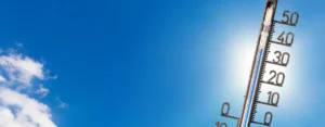 Dieses Bild ist das Titelbild für den Blogartikel zum Thema Hitzeschutz in der Pflege. Auf dem Bild sehen Sie ein Thermometer und einen hellen Himmel.
