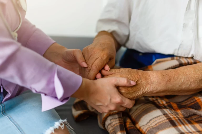 Helfende Hände halten die Hände einer älteren Person